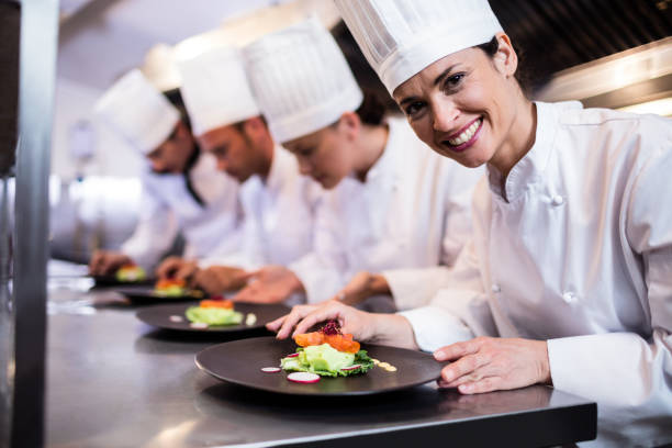 istock Smiling chef with garnished food plate in the kitchen 698535314