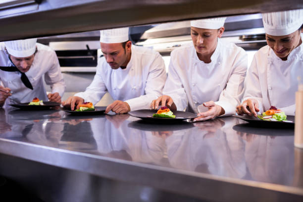 istock Team of chefs garnishing dishes 698535594