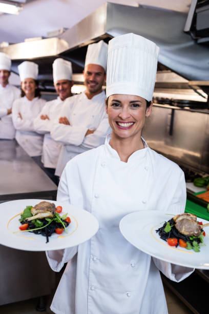 istock Team of chefs with one presenting dishes 698536034