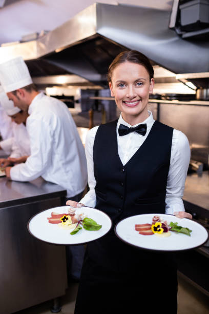 istock Waitress showing dishes to the camera 698541596