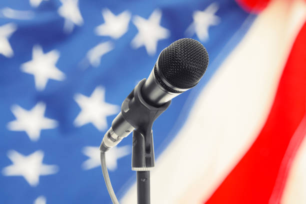 istock Microphone on stand with USA flag on background. Filtered image: cross processed vintage effect. 698561838
