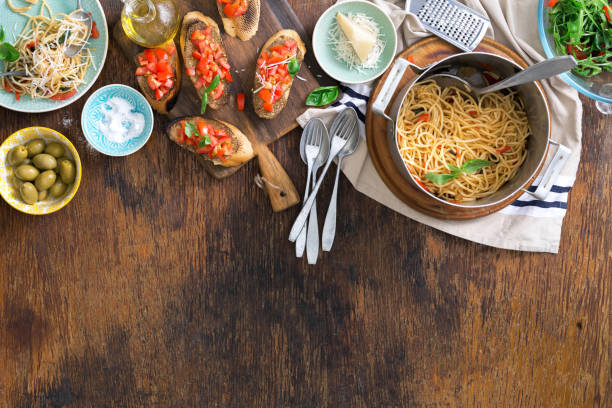 istock Italian pasta and snacks on wooden table with border 698563758