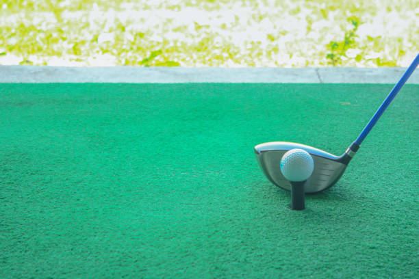 istock golf ball on tee with driver club, in front of driver, driving range 698564110