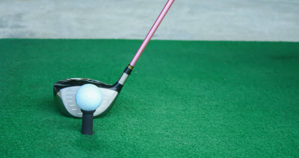 istock golf ball on tee with driver club, in front of driver, driving range 698564172