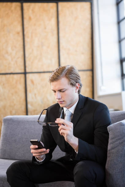 istock Businessman text messaging on mobile phone 698564570