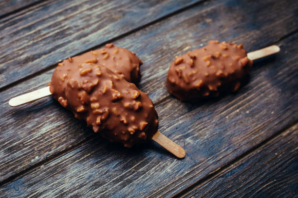 istock Ice cream in chocolate glaze in wooden background 698575314