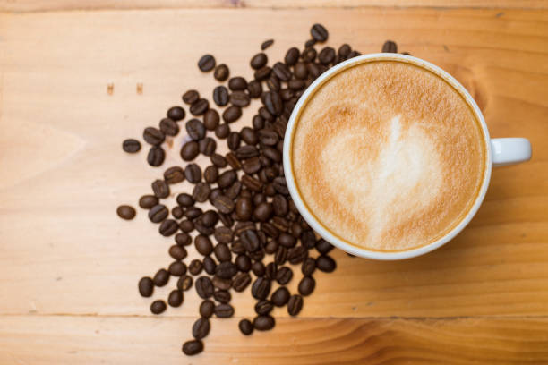 istock Latte art with coffee beans on wood table 698576620