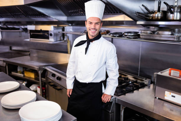 istock Happy male chef standing in kitchen 698582472