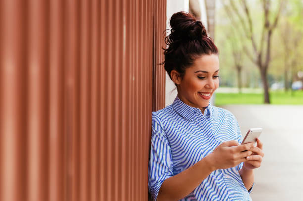 istock Pretty young woman using smartphone outdoors 698582844