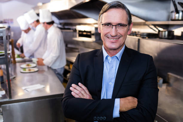 istock Male restaurant manager standing with arms crossed 698583052