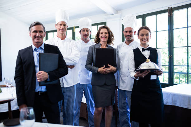 istock Happy restaurant team standing together in restaurant 698583152