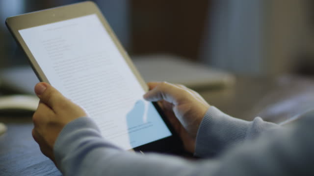 Reading eBook on Digital Tablet in Office