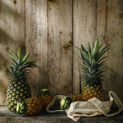 ripe pineapples in basket on white background