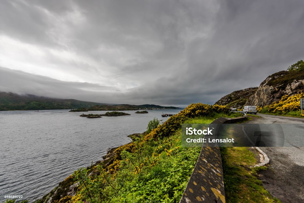 Kyle of Lochalsh - drive along the Loch This is a scenic drive along the loch in Kyle of Lochalsh going toward skye bridge on to isle of skye. This was a cloudy day to add to the drama of the scene Dramatic Sky Stock Photo