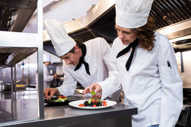 istock Two chefs garnishing meal on counter 698590994