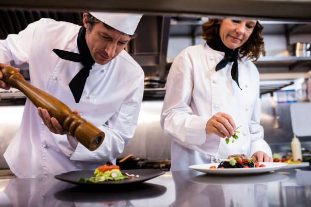 istock Two chefs garnishing meal on counter 698591324