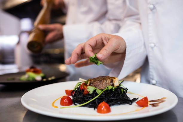 istock Chef garnishing meal on counter 698591454