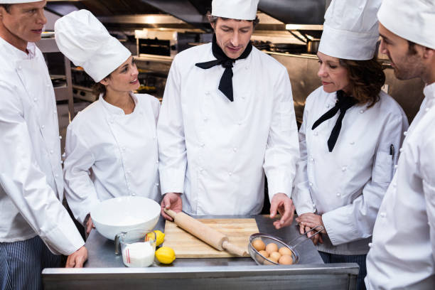 istock Head chef teaching his team to prepare a dough 698592384