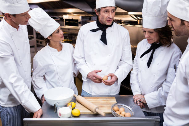 istock Head chef teaching his team to prepare a dough 698593928