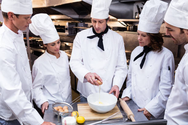 istock Head chef teaching his team to prepare a dough 698594054