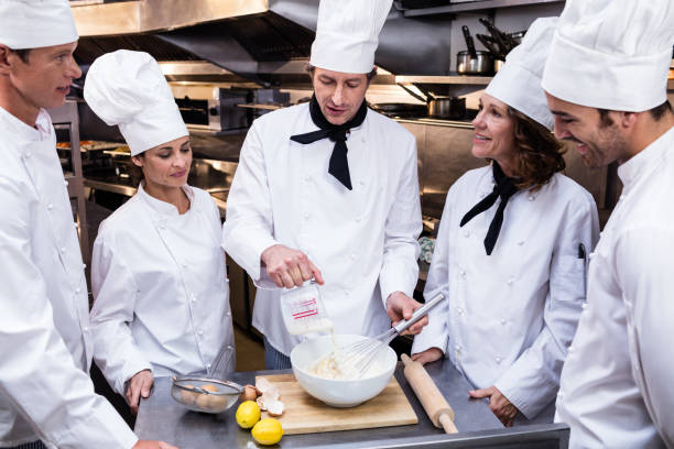 istock Head chef teaching his team to prepare a dough 698594292