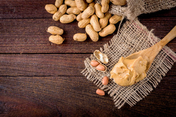 burro di arachidi e arachidi sul pavimento di legno - peanut bag nut sack foto e immagini stock
