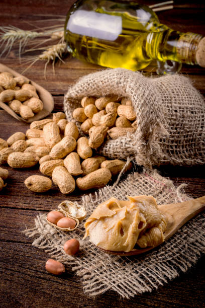 burro di arachidi e arachidi sul pavimento di legno - peanut bag nut sack foto e immagini stock