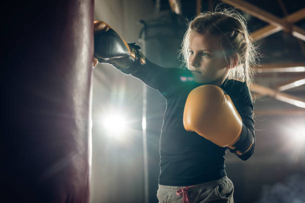 istock Determined little girl punching a bag on a boxing training. 698608276