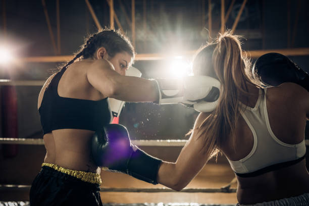 istock Two female boxers fighting during a boxing match in a ring. 698610728