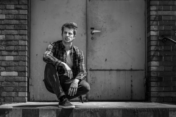 young man crouching on ramp of warehouse