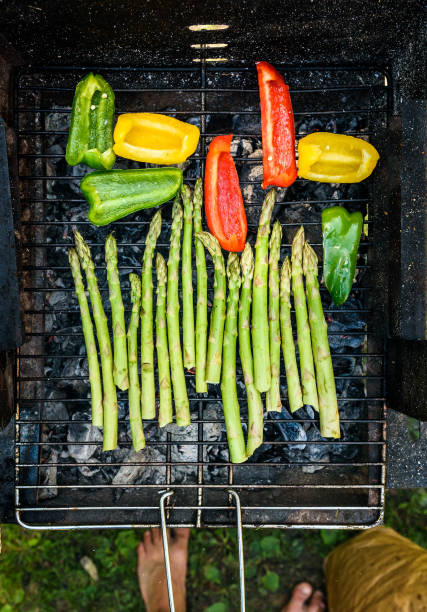 istock Asparagus and bell peppers on a barbecue bbq charcoal grill. 698622556