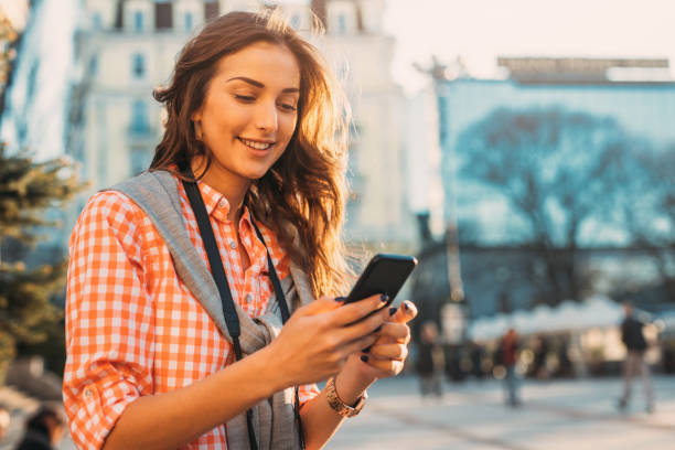 istock Beautiful woman texting outdoors 698627930