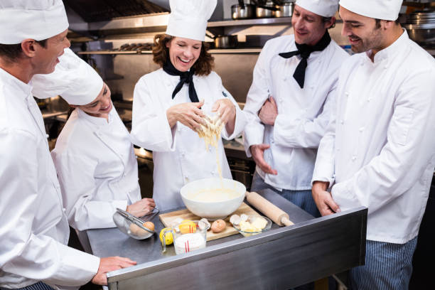 istock Head chef teaching his team to prepare a dough 698628446
