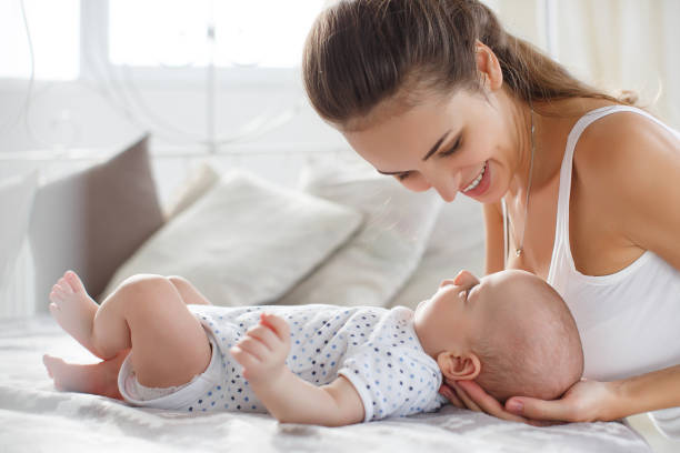 istock Mother playing with her newborn son lying on bed 698635986