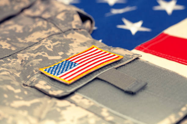 istock USA flag with army uniform over it - studio shot. Filtered image: cross processed vintage effect. 698636582