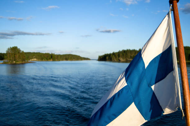 Idyllic Saimaa scene with a Finnish flag Finnish flag contains the matching colors of the water and the sky saimaa stock pictures, royalty-free photos & images