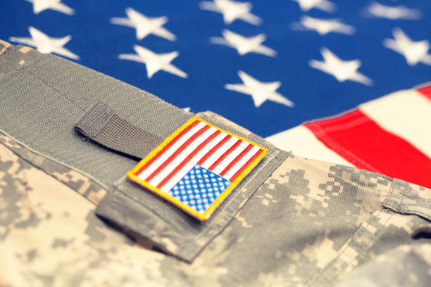 istock USA flag with army uniform - close up studio shot. Filtered image: cross processed vintage effect. 698638324