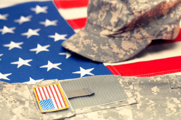 istock USA flag with US military uniform over it - studio shot. Filtered image: cross processed vintage effect. 698639180