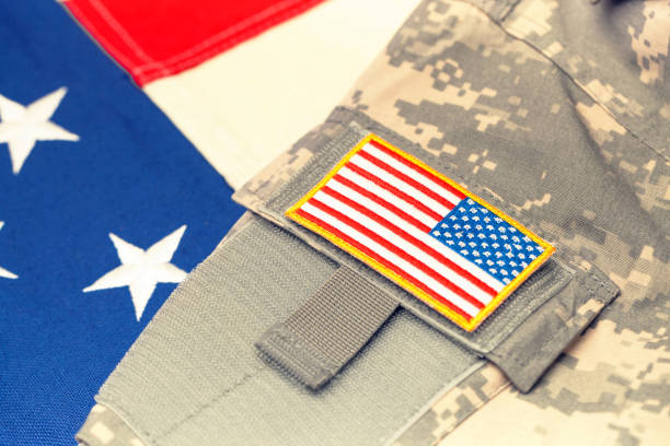 istock USA army uniform with chevron over flag - focus on chevron. Filtered image: cross processed vintage effect. 698639352