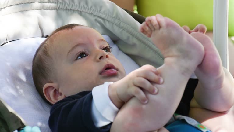 Baby lying on back and holding onto feet