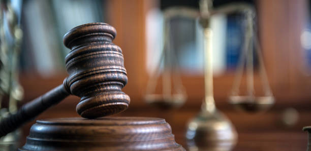 Law and Justice concept. Mallet of the judge, books, scales of justice. Law and Justice concept. Mallet of the judge, books, scales of justice. Gray stone background, reflections on the floor, place for typography. Courtroom theme. british judges stock pictures, royalty-free photos & images