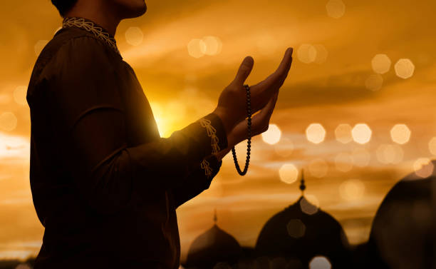 Muslim man raising hand and praying with prayer beads Muslim man raising hand and praying with prayer beads during sunset background alternative pose photos stock pictures, royalty-free photos & images