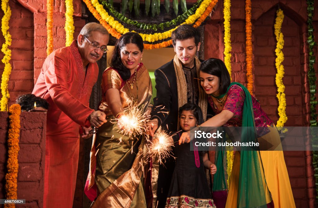 Indian Family celebrating Diwali festival with fire crackers Diwali Stock Photo