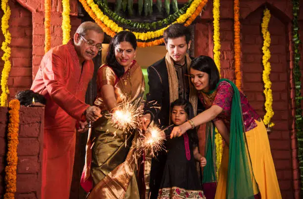 Photo of Indian Family celebrating Diwali festival with fire crackers