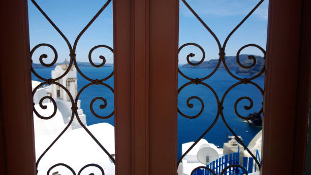 dekorativa mönstrade dörr i santorini - fokus i förgrunden. i bakgrunden det blå havet och vita huset - santorini door sea gate bildbanksfoton och bilder