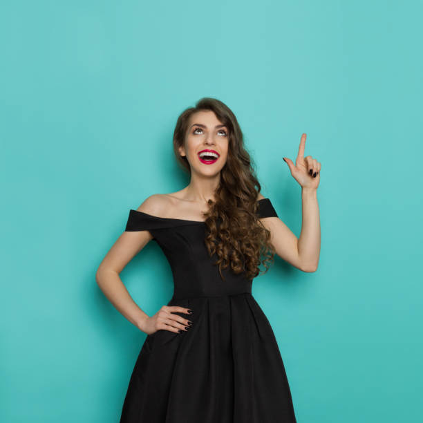 istock Happy Elegant Woman Is Looking Up And Pointing 698717486