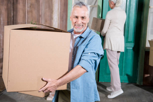 istock Happy senior man holding cardboard box and smiling at camera 698731308