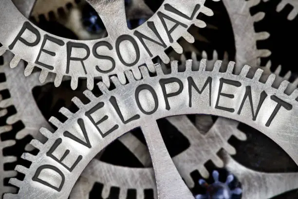 Macro photo of tooth wheel mechanism with PERSONAL DEVELOPMENT letters imprinted on metal surface