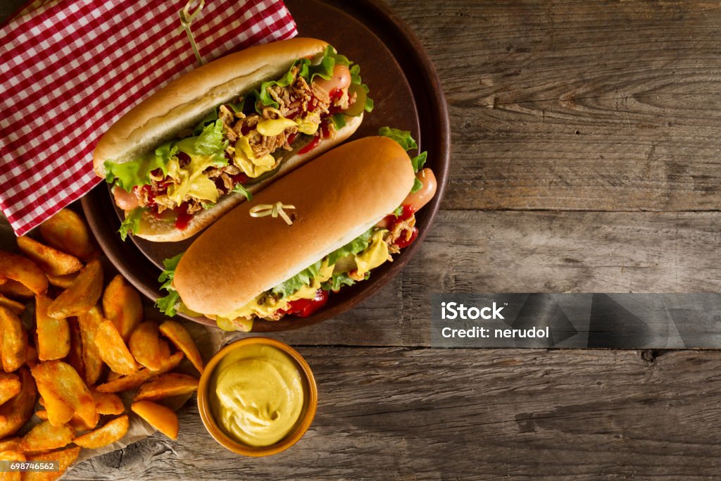 Variety of classic traditional american tasty junk unhealthy food on wooden background with copy space. Hot Dogs and Chips. Hot Dog Stock Photo