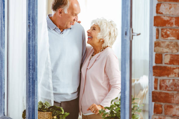 istock Couple laughing by the window 698752752